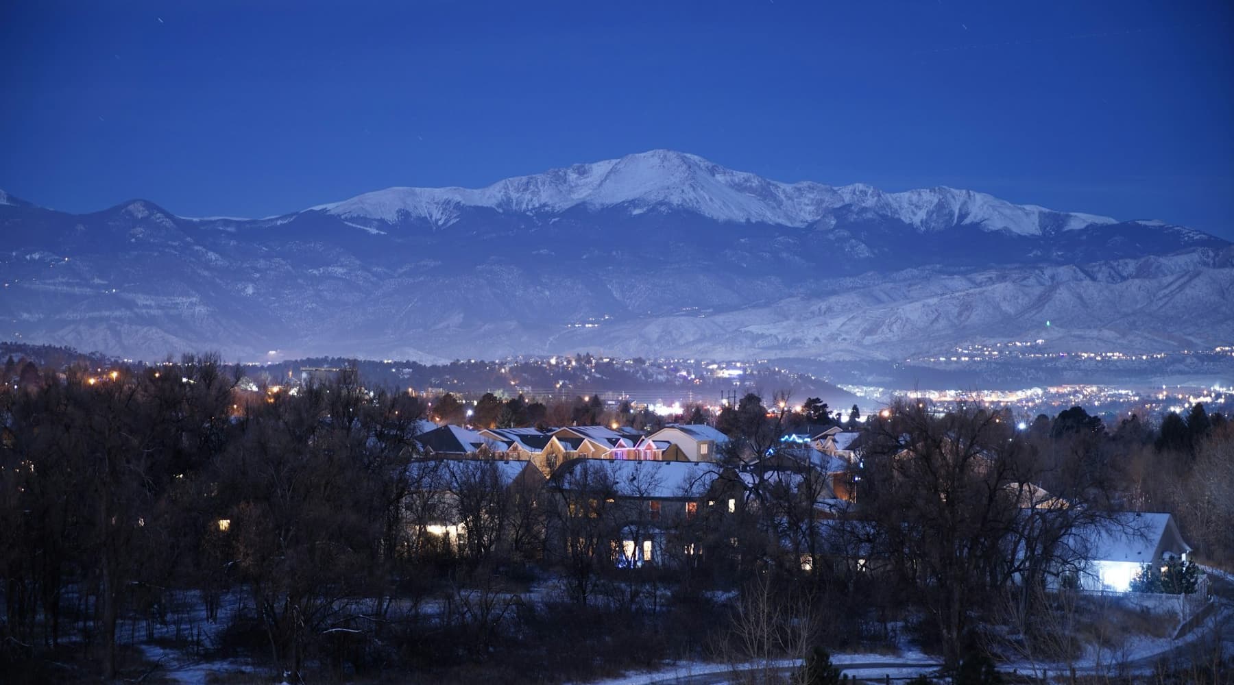 Pikes Peak over Colorado Springs neighborhoods at dusk